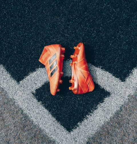 Orange football boots laying on corner of football pitch