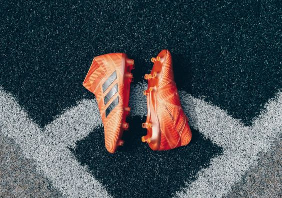 Orange football boots laying on corner of football pitch