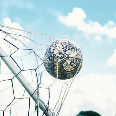 Football striking the back of a football goal net - Photo by chaossoccergear